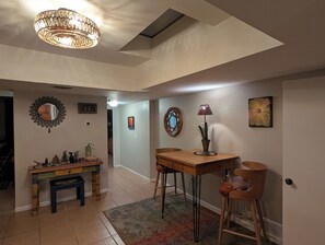 A dining area with a table, chairs, a lamp, and a decorative mirror. - Sabino Sanctuary Townhome (Tucson)