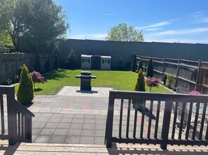 A backyard with a patio, a barbecue grill, a small shed, and a wooden fence. - Perfect Falls Location retreat (Niagara Falls)