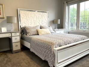 A bedroom with a bed, bedside tables, and a window. - Perfect Falls Location retreat (Niagara Falls)