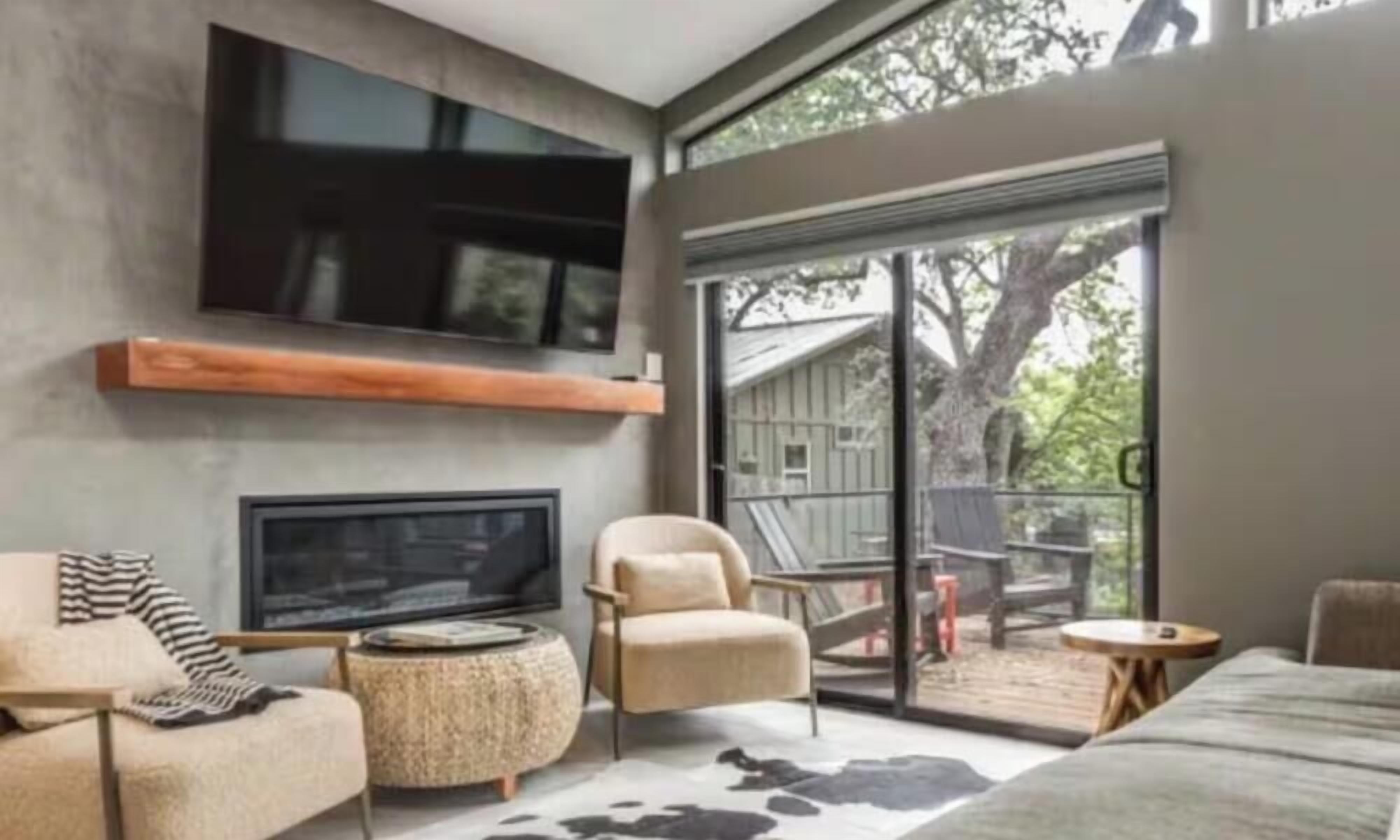 A modern living room with a flat-screen TV, a sofa, a chair, and a coffee table.