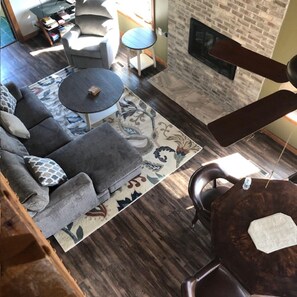 Ein Wohnzimmer mit einer Couch, einem runden Couchtisch, einem Kamin und einem gemusterten Teppich.