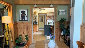 A dining area with a wooden table, chairs, a vase with flowers, and a ceiling fan. - Pet friendly Lakefront House with hot tub and large Deck on Summit Lake (Argyle)