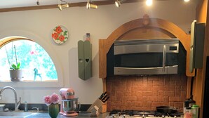 A kitchen with a central island, a microwave, a stove, and a sink. - Pet friendly Lakefront House with hot tub and large Deck on Summit Lake (Argyle)