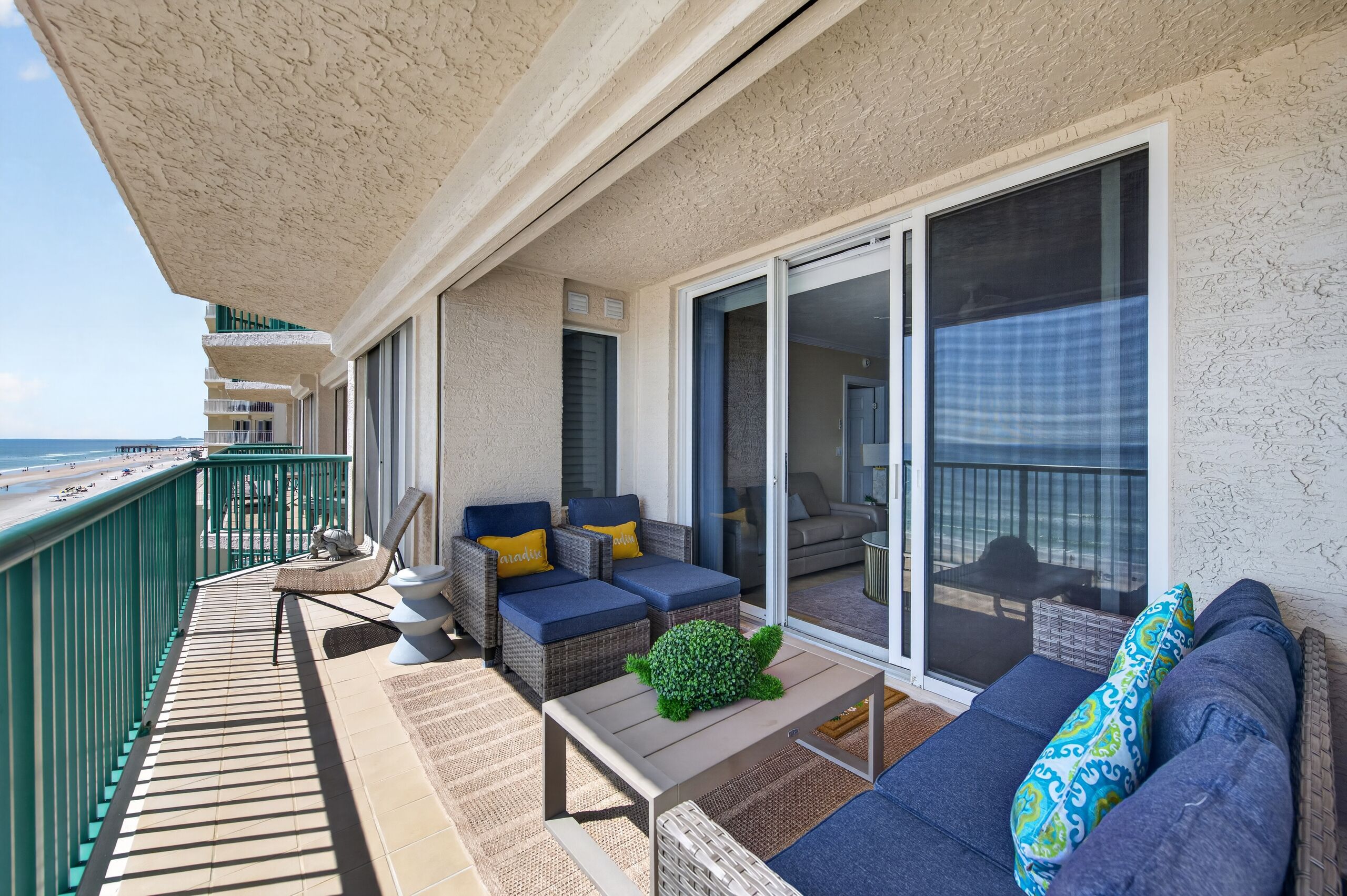 A balcony with outdoor furniture, a small table, and a green decorative item.