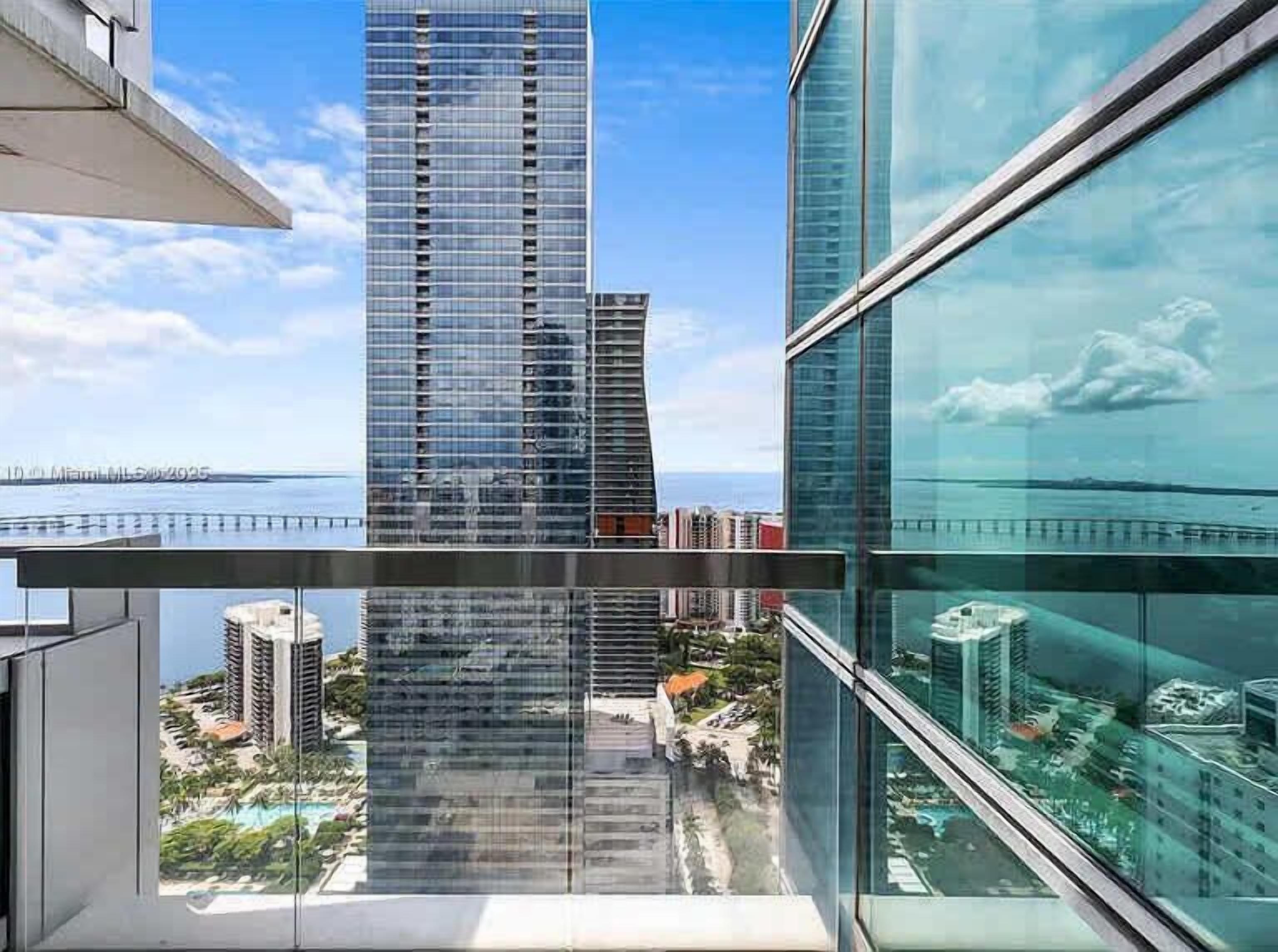 A high-rise building with a view of a marina and other buildings.