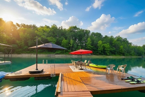 Private lakefront dock with kayaks, lounge seating, and peaceful forest views