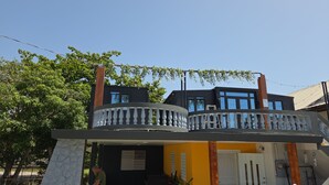 Ein zweist öckiges Gebäude mit Balkon, einer Tür und einem Fenster.
