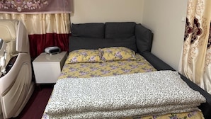 A bedroom with a bed, a nightstand, a chair, a curtain, and a wall decoration. - Spacious & lovely apartment available in Rødovre, CPH. (Rødovre)