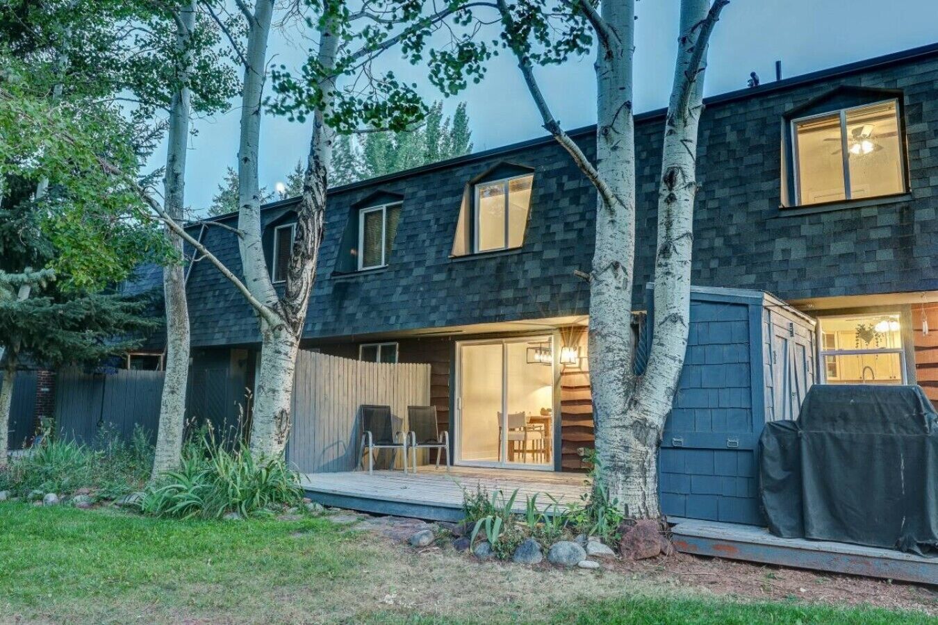 Ett modernt hus i två våningar med en täckt uteplats och ett köksområde som är synligt från utsidan.