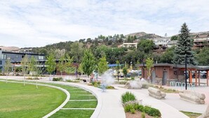 A landscaped area with a curved pathway, seating areas, and a water feature.