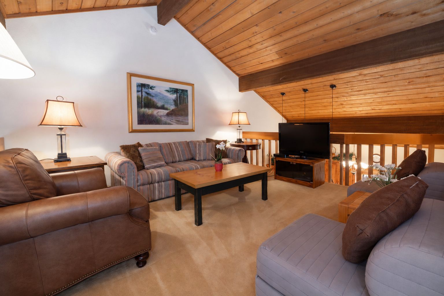 Ein gemütliches Wohnzimmer mit einer Couch, einem Couchtisch und einem Fernseher.