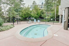 A swimming pool with a curved edge, surrounded by a fence, and trees in the background. - Vail Simba Run 2 BR Condo with Resort Facilities (Vail)