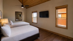 A bedroom with two beds, a ceiling fan, a TV, and windows with blinds. - Modern Luxury 4 Bedroom/4 Bathroom Cabin w/ AC + Free Access to Waterpark (Gatlinburg)