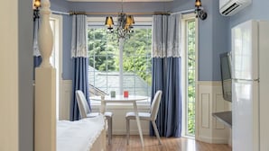 A room with a bed, a table with chairs, a chandelier, and a window with curtains. - Hongcheon Tasha's Garden Pension (Hongcheon)