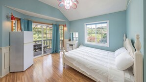 A bedroom with a bed, a desk, a wardrobe, and a balcony with a view. - Hongcheon Tasha's Garden Pension (Hongcheon)