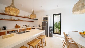 Une cuisine moderne avec des tabourets en bois, un évier encastré et un grand îlot central.