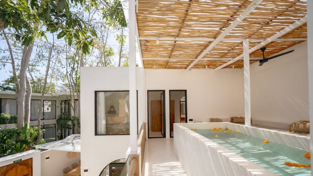 Un espace bien-être comprenant un jacuzzi, une terrasse en bois et un coin salon abrité.
