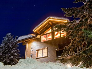 Ein mit Schnee bedecktes Chalet mit einem sichtbaren 'SWISS'-Schild, das einen Ort in der Schweiz kennzeichnet.