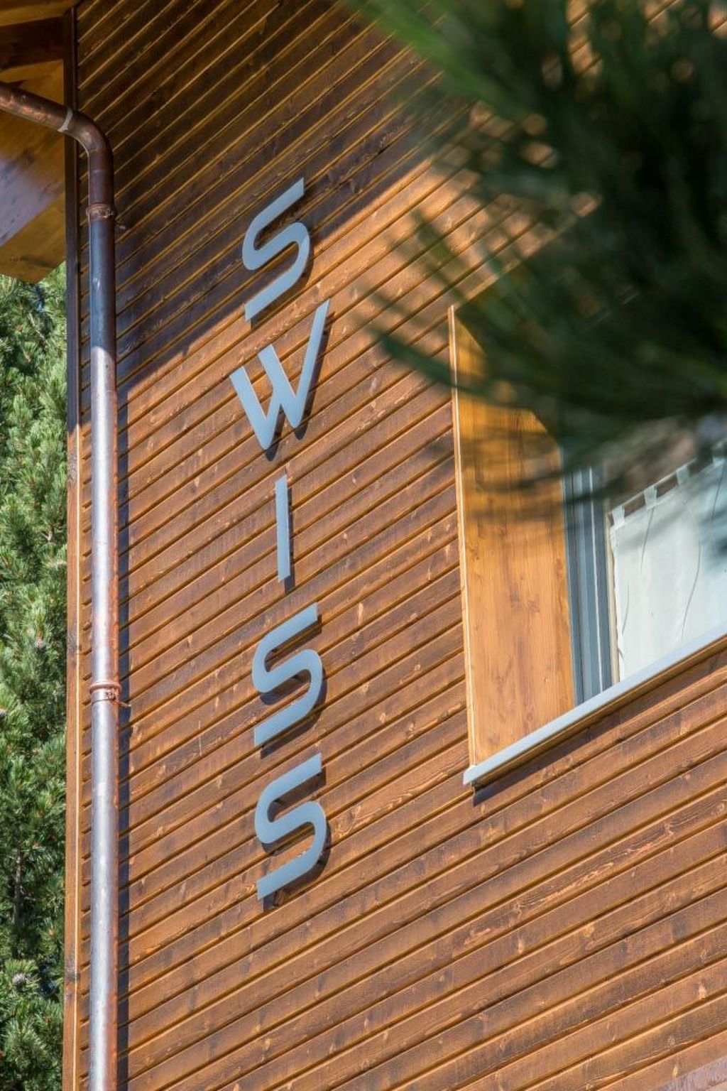 Eine Holzwand, auf der das Wort 'SWISS' in Großbuchstaben steht.