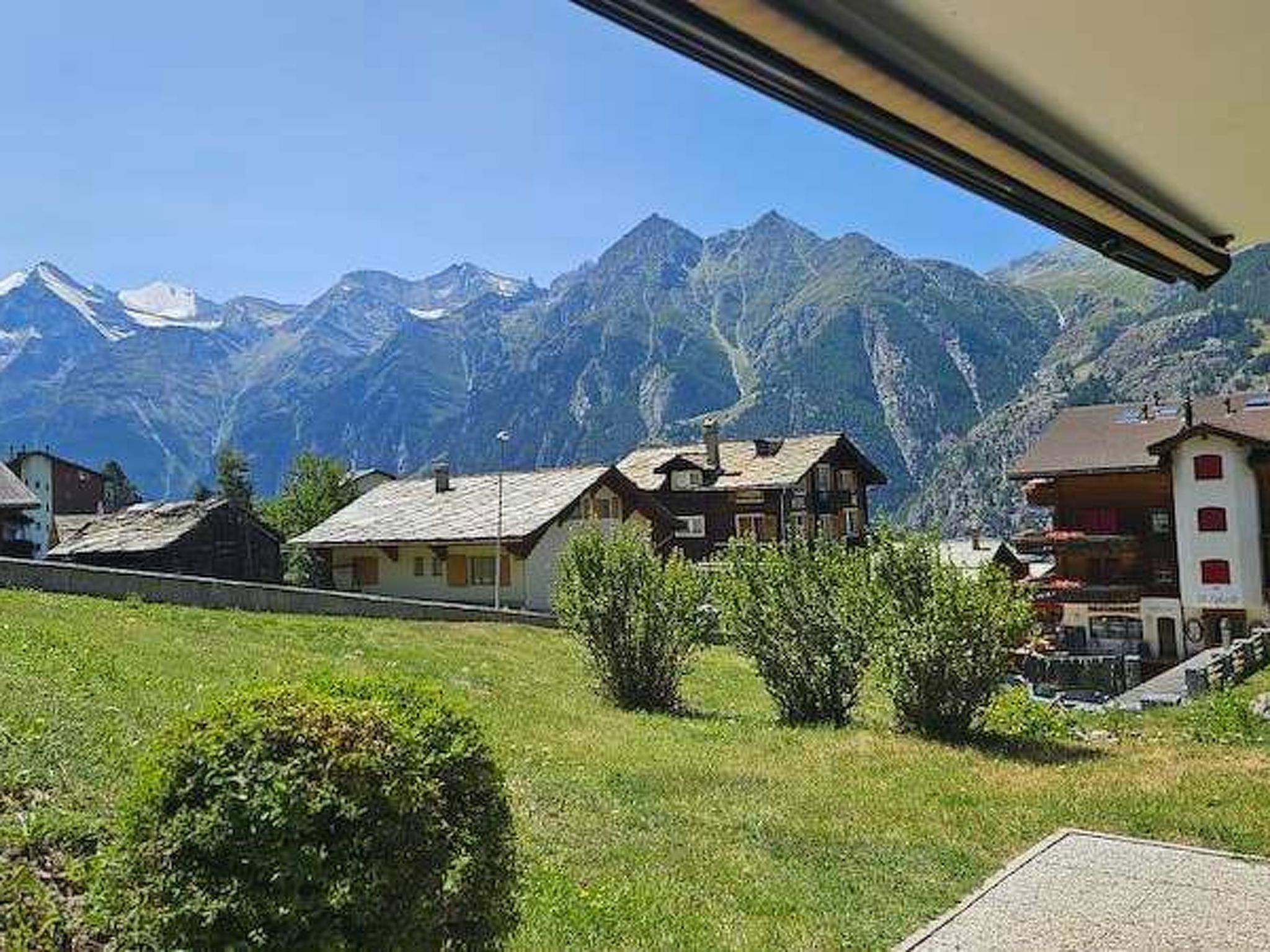 A mountain village with traditional houses and a clear view of snow-capped peaks.