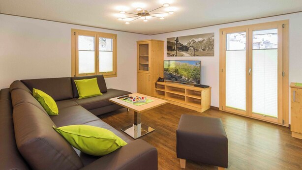 Ein modernes Wohnzimmer mit einer Couch, einem Couchtisch, einem Fernseher und einem Schrank.