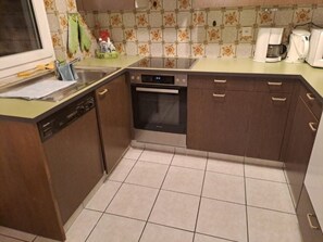 A compact kitchen with a dishwasher, oven, and a coffee maker. - Residence Fewo SARAH, (Grächen), 2031 by Interhome (Grächen)