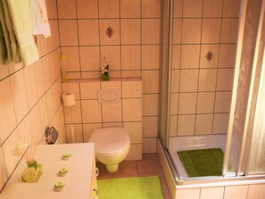 A bathroom with a toilet, a shower, and a sink. - Ferienwohnungen Zur Heimat, (Grächen), by Interhome (Grächen)