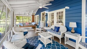 A covered porch with wicker furniture, a ceiling fan, and a view of the outdoors. - Sunnyside Creek House | Hidden Inlet Escape Est'38 (Murrells Inlet)
