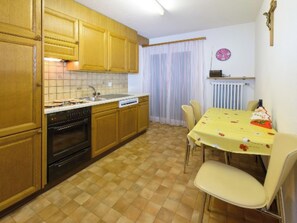 Eine Küche mit Holzausstattung, einem Geschirrspüler und einem Esstisch mit Stühlen.