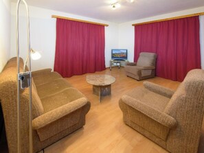 Ein Wohnzimmer mit zwei Sofas, einem Couchtisch und einem Fernseher.