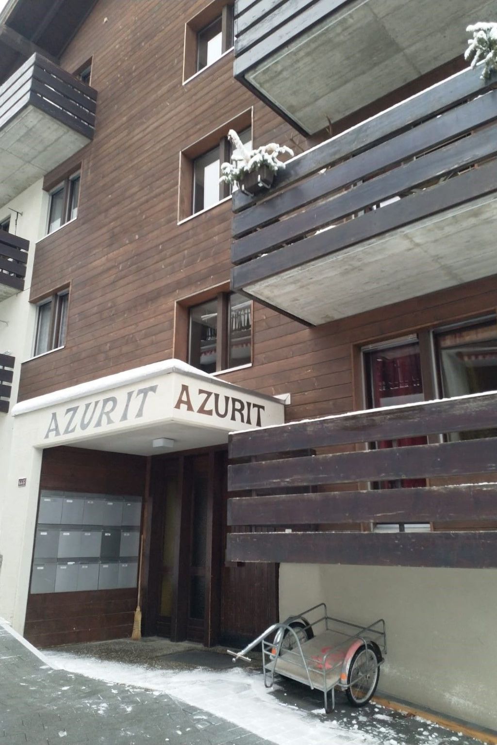 A building with a sign reading 'AZURIT AZURIT' and a covered entrance.