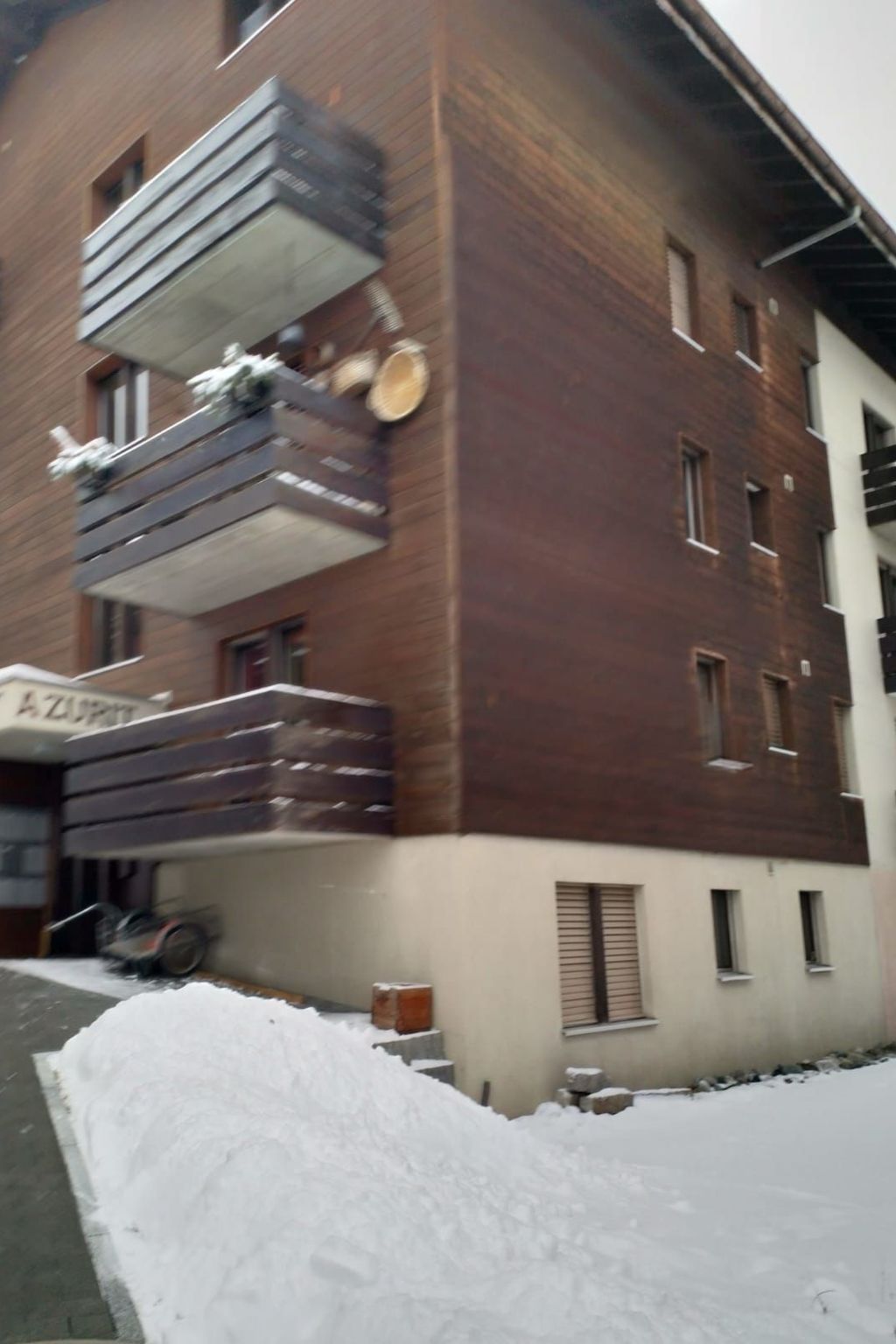 Un immeuble à plusieurs étages, doté d’une façade en briques et d’un balcon agrémenté de balustrades.
