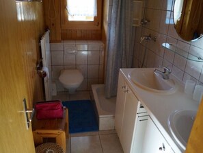 Une petite salle de bain comprenant des toilettes, un lavabo et un espace douche.