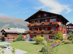 A multi-story hotel with balconies, a ski lift, and a mountainous backdrop. - Ferienwohnungen Bel Air, (Grächen), 1292 & 1575 by Interhome (Grächen)