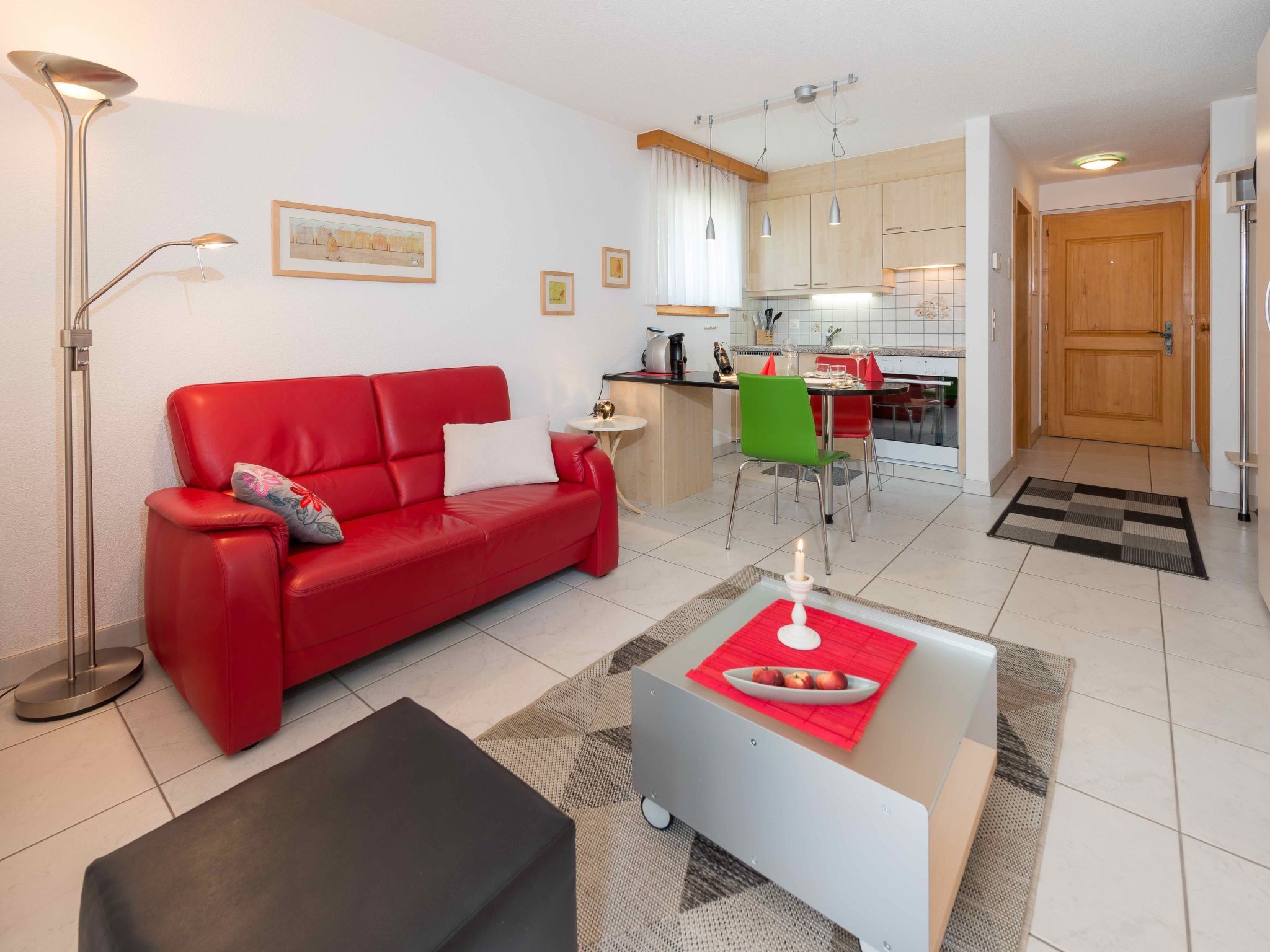 Una sala de estar moderna con un sofá rojo, una mesa de centro y una lámpara de pie.