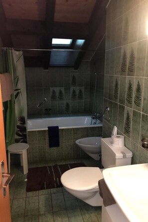 Ein Badezimmer mit Badewanne, Toilette, Bidet und Waschbecken.