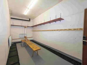 Ein Zimmer mit einer Bank, einem Heizkörper und einem Wandregal.