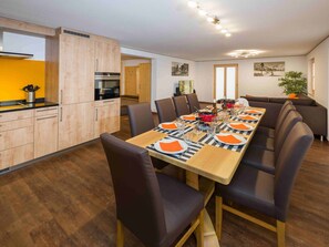 A modern dining area with a long table set for six, surrounded by chairs. - Ferienwohnungen Lunic, AZapartments.ch, B&B, (Grächen), 1057 by Interhome (Grächen)