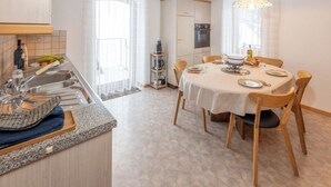 Una cocina con una mesa de comedor, sillas y una araña.