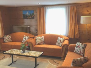 A cozy living room with two sofas, a coffee table, and a painting on the wall. - Sunnegga, (Grächen), by Interhome (Grächen)