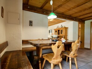 A wooden dining table with chairs, a bench, and a hanging light fixture. - Ferienwohnungen Goldblick, (Grächen), 1767+1034+2083 by Interhome (Grächen)