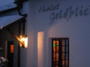 A building with a sign that reads 'Chalet Goldblitz' and a window with a green light visible inside. - Ferienwohnungen Goldblick, (Gr ächen), 1767+1034+2083 by Interhome (Grächen)