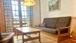 Una mesa de madera y un sofá en una habitación con un cuadro en la pared.