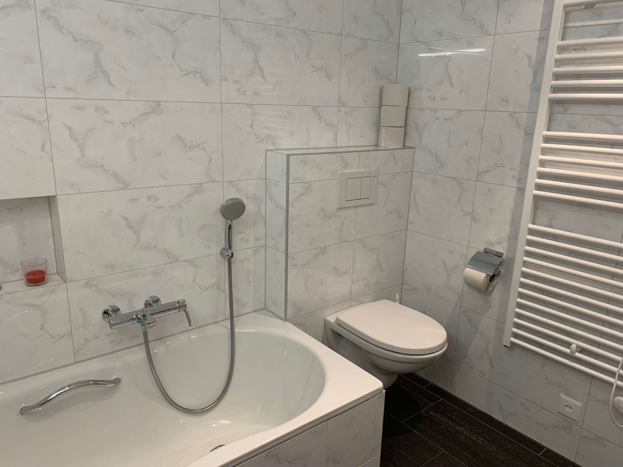 Ein Badezimmer mit einer Badewanne, einer Toilette und einer Dusche.