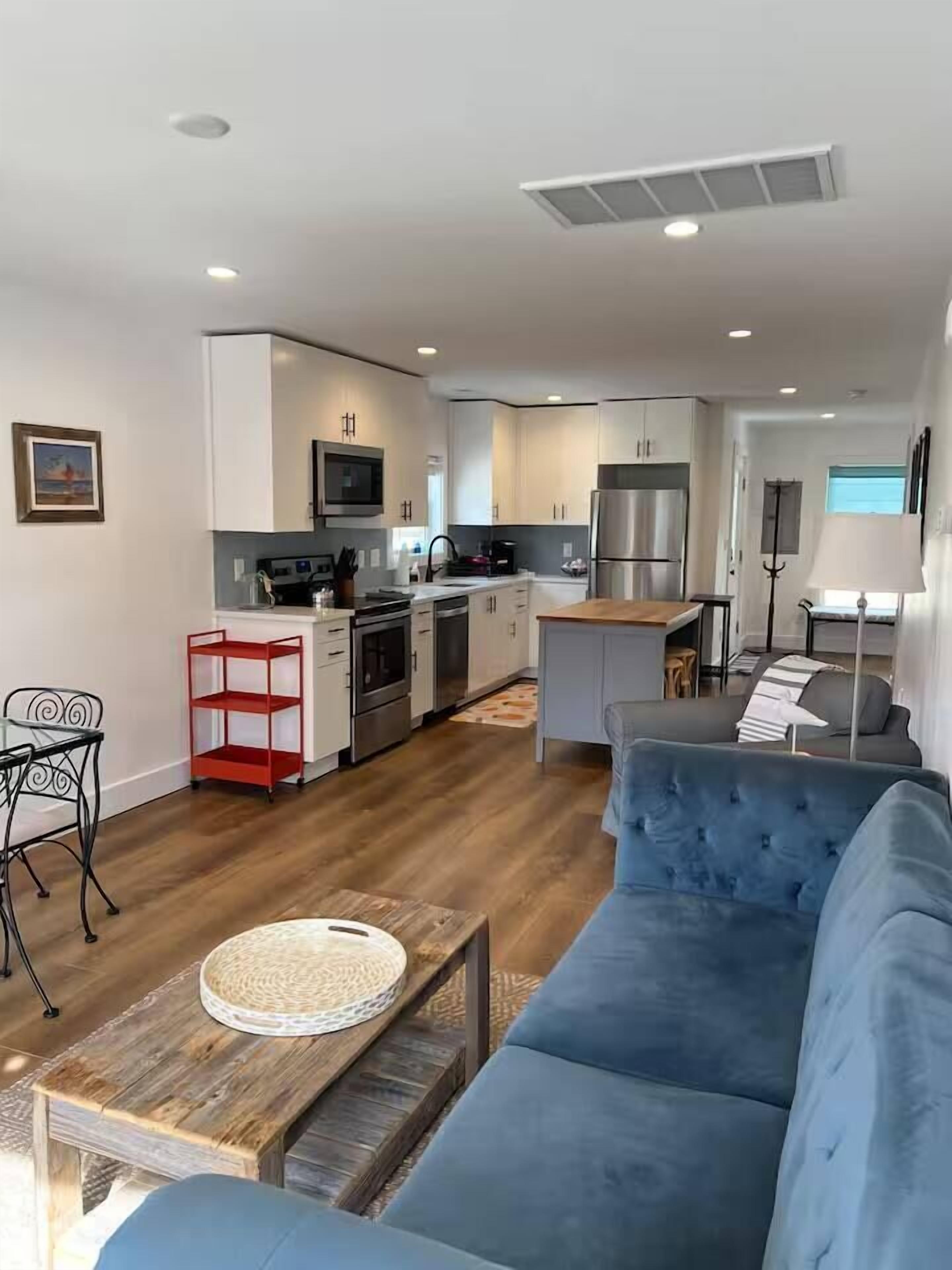 A modern apartment with a living room, kitchen, and dining area.