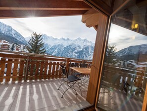 Ein Holzbalkon mit Blick auf schneebedeckte Berge.