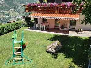 A house with a patio, a swing set, and a view of the surrounding landscape. - Schneevogul, (Grächen), 1114 by Interhome (Grächen)