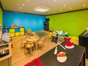 A children's playroom with a round table, chairs, and various toys. - Ferienwohnungen Lunic, AZapartments.ch, B&B, (Grächen), 1057 by Interhome (Grächen)