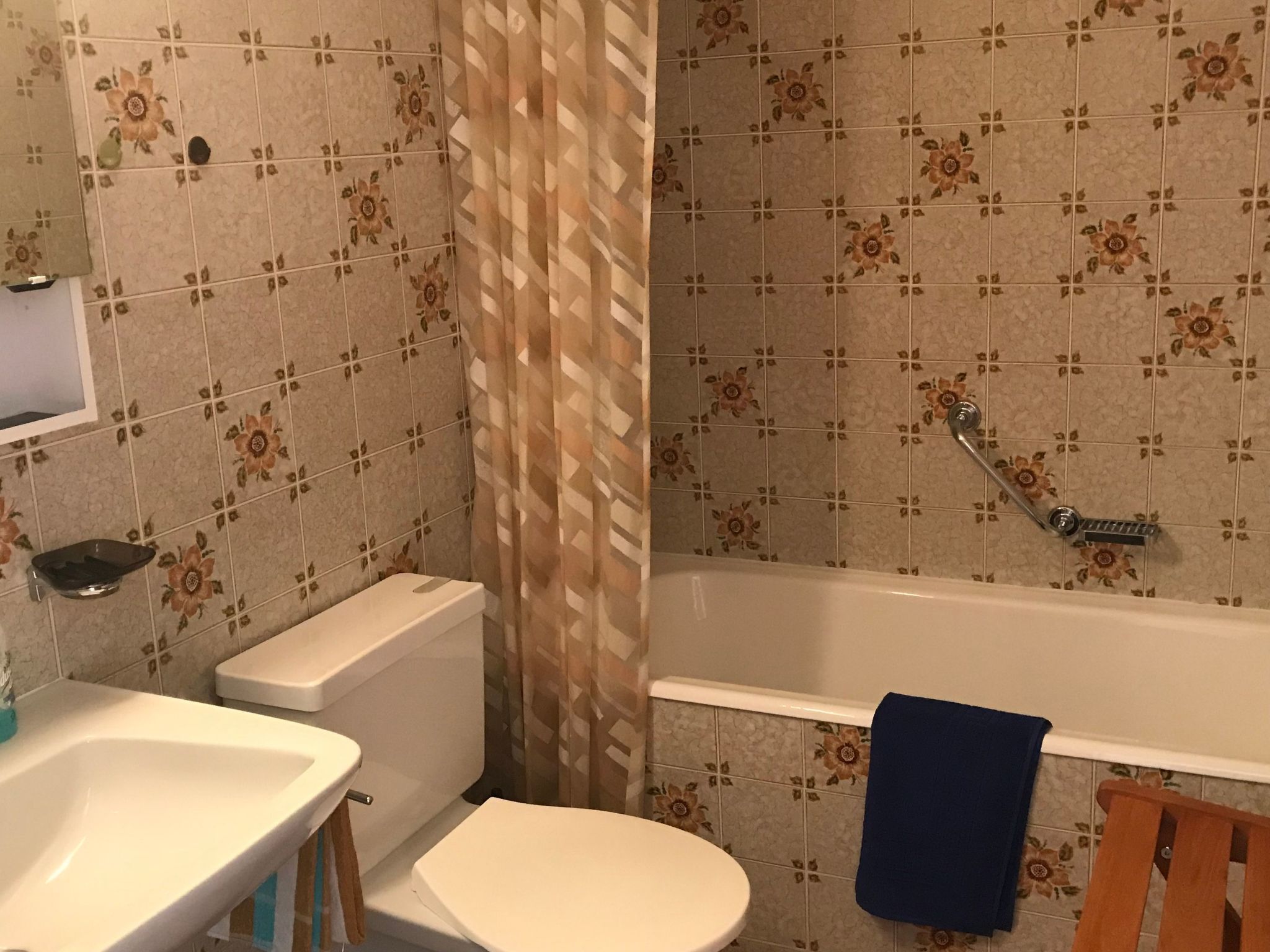 Een badkamer met toilet, wastafel en bad.