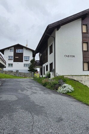 Ein Gebäude mit der Aufschrift 'CASTOR' auf der Fassade, einer gepflasterten Auffahrt und einer Steinmauer.